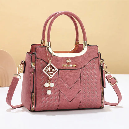 Dámska crossbody kabelka s prešívaním v tvare písmena V, kovaniami v zlatej farbe, viacerými priehradkami a hornou rukoväťou.