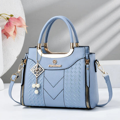 Dámska crossbody kabelka s prešívaním v tvare písmena V, kovaniami v zlatej farbe, viacerými priehradkami a hornou rukoväťou.